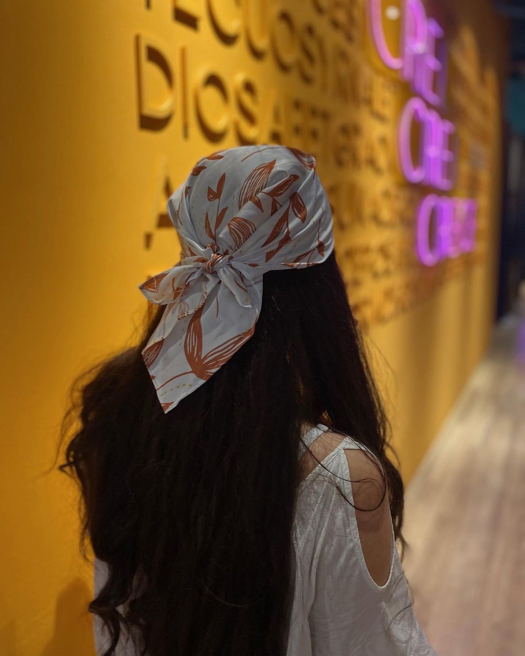 ผู้หญิงฝรั่งหันหลัง ไว้ผมยาวสีดำ โพกศรีษะด้วยผ้าคลุมผม