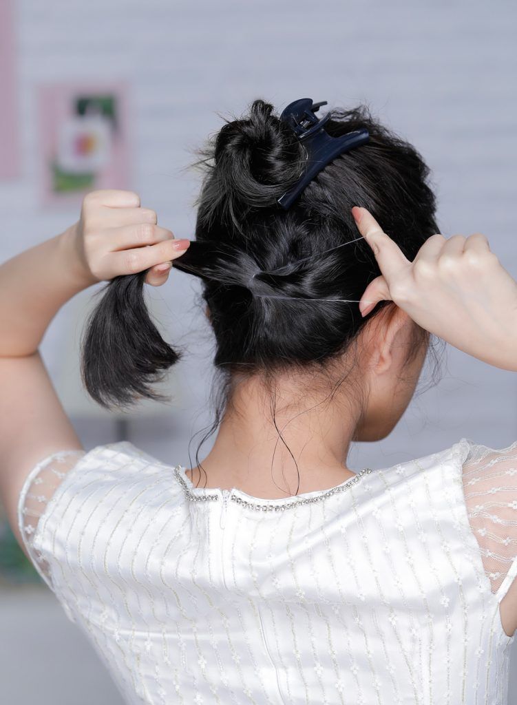 ผู้หญิงเอเชียผมหยักศกยาวประบ่า เกล้าผมมวยต่ำ