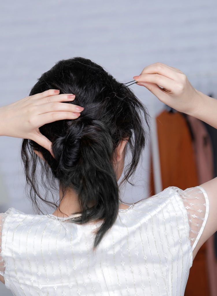 ผู้หญิงเอเชียผมหยักศกยาวประบ่า เกล้าผมมวยต่ำ