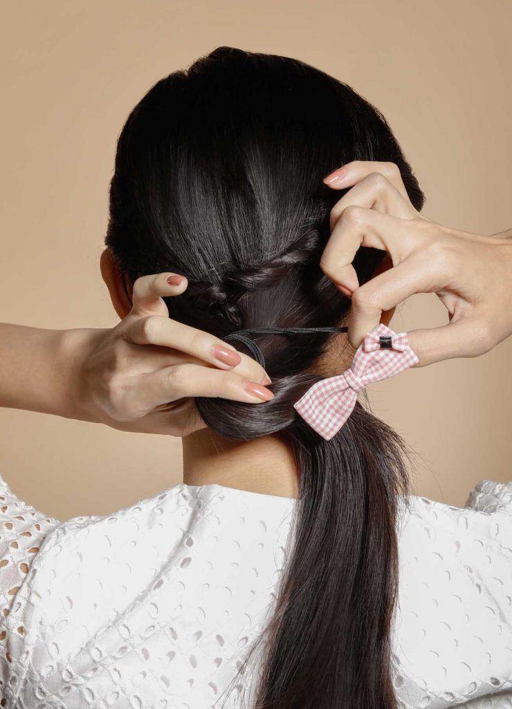 ผู้หญิงเอเชียผมยาวสีดำ กำลังผูกผม