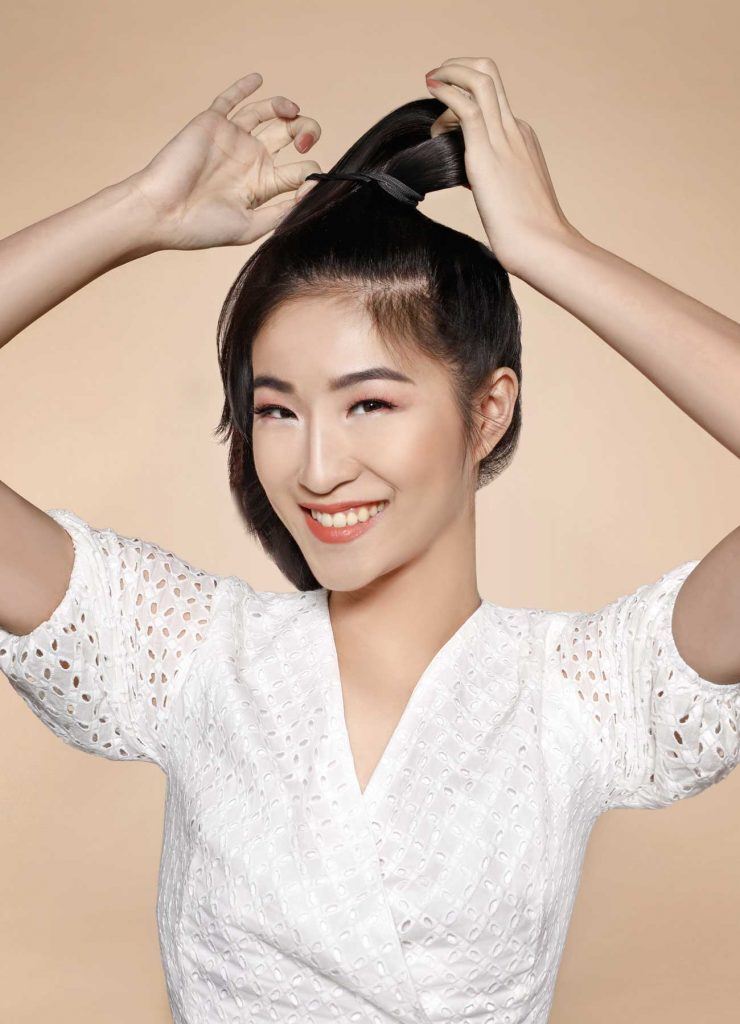 ผู้หญิงเอเชียผมยาวสีดำ กำลังมัดผม