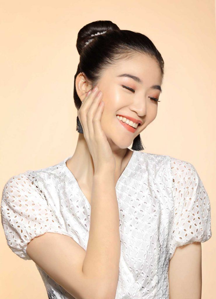 ผู้หญิงเอเชียผมยาวสีดำ กำลังเกล้าผมบัน