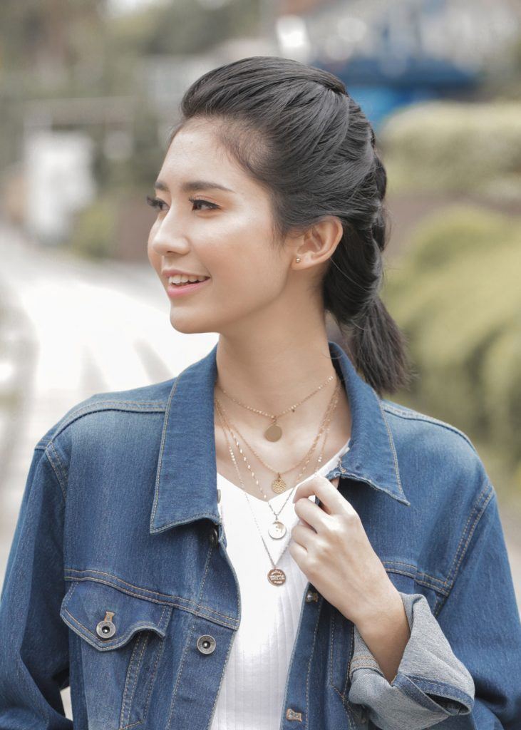 ผู้หญิงเอเชียผมสั้น ใส่เสื้อยืดสีขาว สาธิตวิธีถักเปียนูน เปียนูนผมสั้น