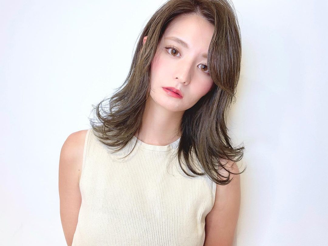 ผู้หญิงเอเชียไว้ผมยาวประบ่า ผมสีน้ำตาลเข้ม ทรงผมดัดปลาย