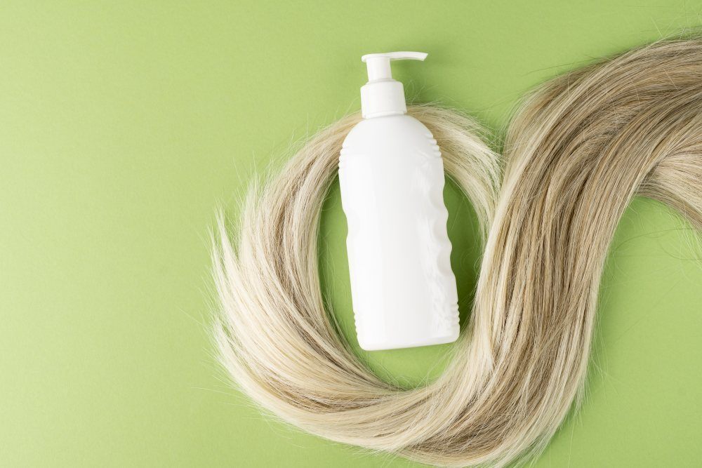 ขวดหัวปั๊ม สีขาว วางบน ปอยผมสีทอง 