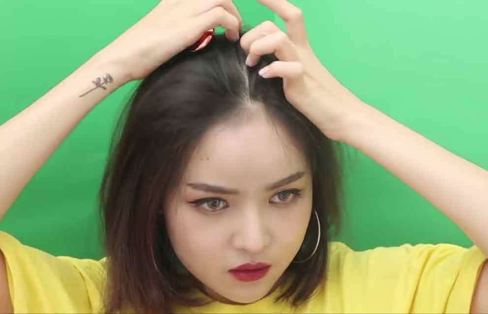 อินฟลูเอนเซอร์ไทย mynjimye กำลังใช้นิ้วมือสองข้างแบ่งผมแสกข้างผม