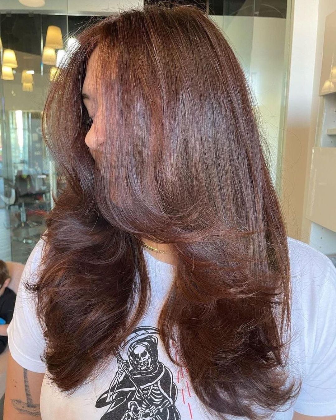 ผู้หญิงฝรั่ง ไว้ผมยาวสีน้ำตาลเข้มและดัดลอน ทรงผมดัดปลาย