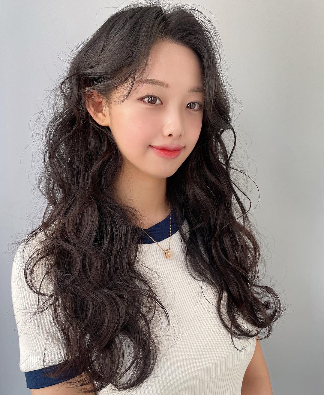 ผู้หญิงเอเชีย ไว้ผมยาวสีดำและดัดลอน ทรงผมดัดปลาย