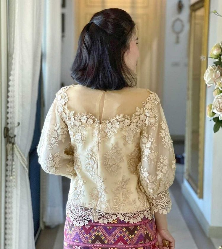 ผู้หญิงใส่เสื้อลูกไม้ ผ้าซิ่น หันหลัง ทรงผมบ็อบยาวประบ่ารวบครึ่งหัว