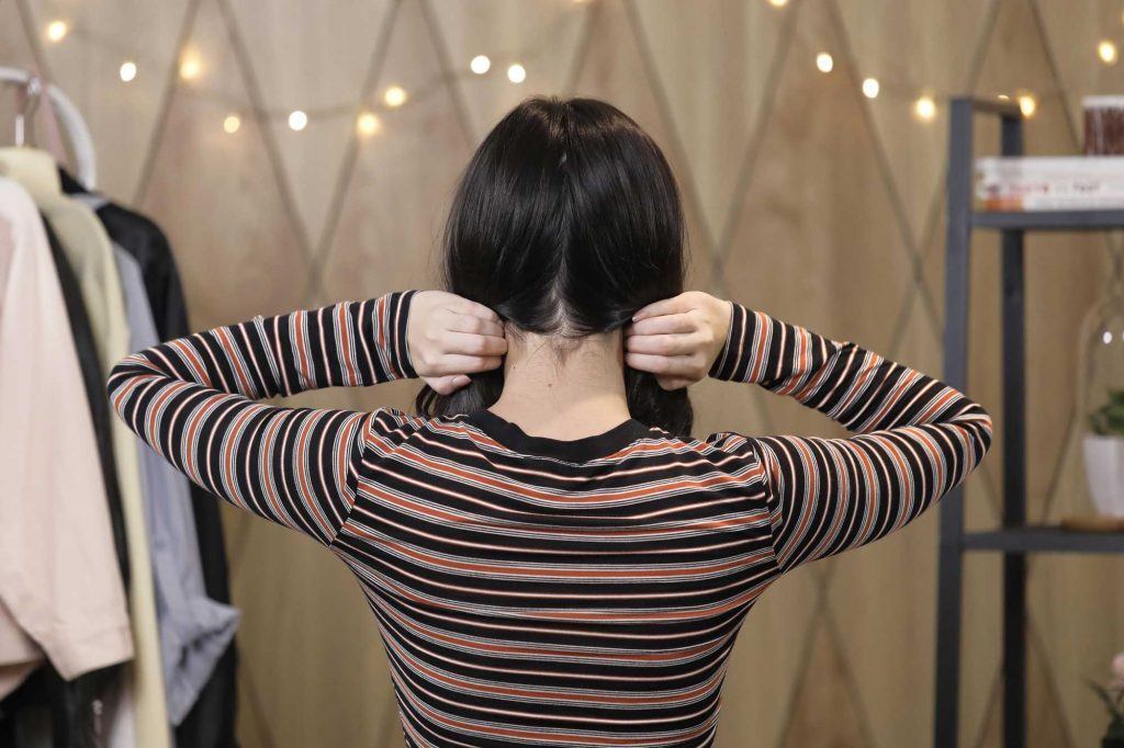 ผู้หญิงเอเชียผมประบ่าสีดำ กำลังแบ่งผมเป็น 2 ข้าง