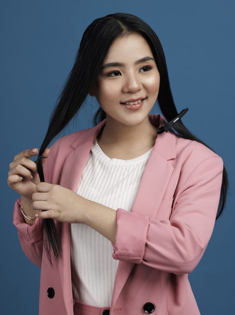 ผู้หญิงผมยาวสีดำ มัดผมหางม้า สวมสูทสีชมพู