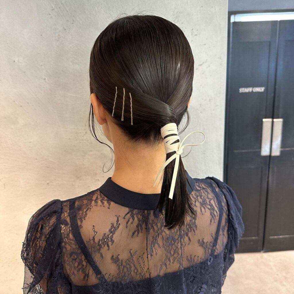 ผู้หญิง หันหลัง ผมรวบตึง ทรงหางม้าต่ำ ติดริบบิ้นเกลียว