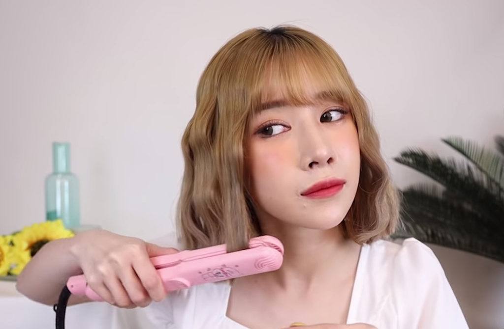 สาวไทย ใช้แกนหนีบผม ม้วนปลายผม ให้งุ้มเข้า