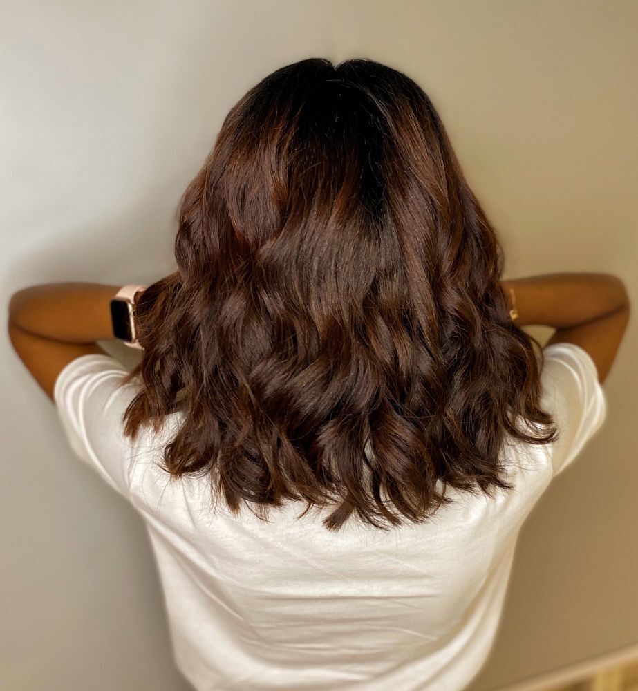 ผู้หญิงฝรั่งยืนหันหลัง ไว้ผมบ๊อบประบ่า สีน้ำตาลเข้ม ดัดปลายผม