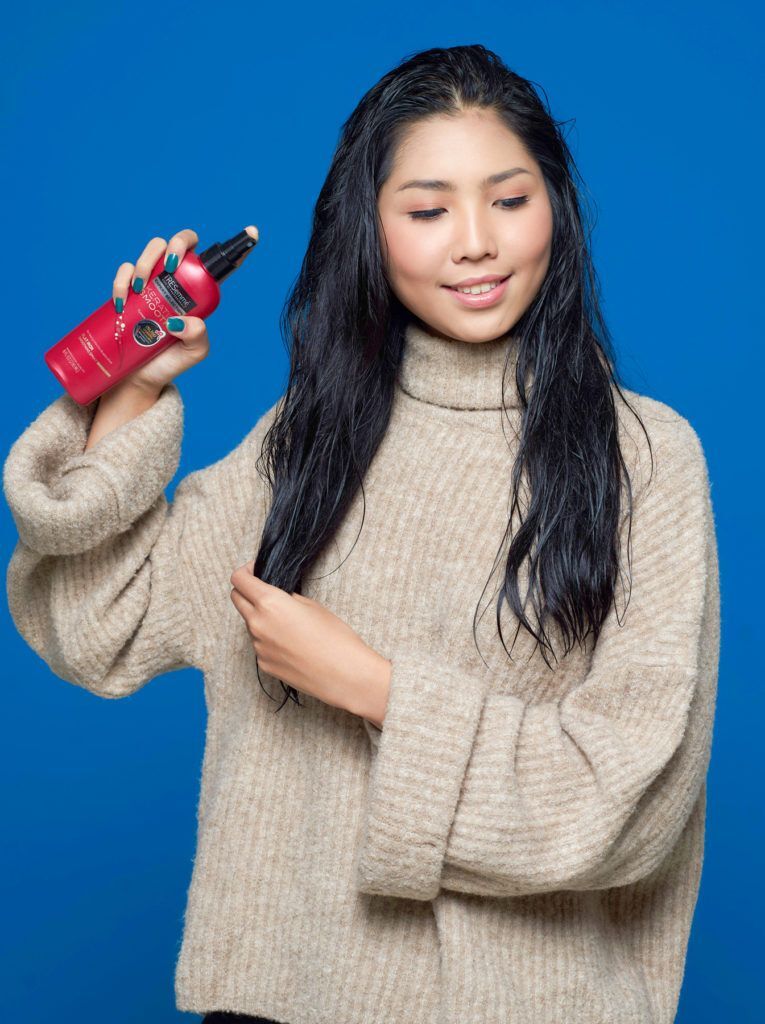 ผู้หญิง เอเชีย ไว้ผมยาว ฉีดสเปรย์กันความร้อน บนเส้นผม