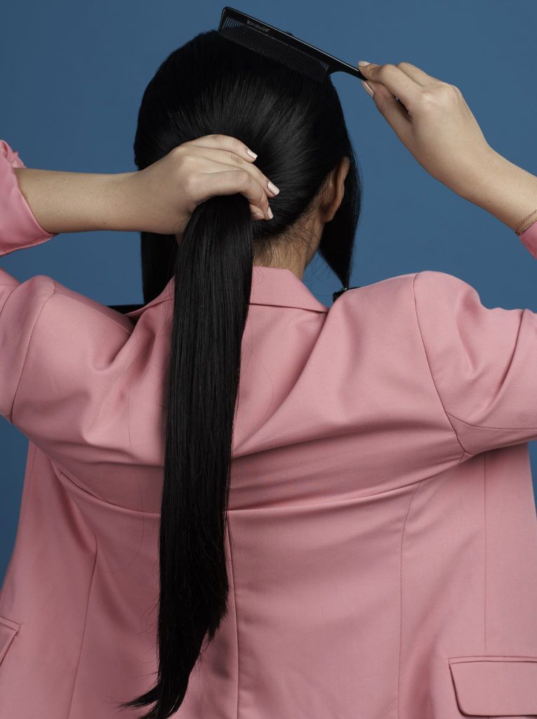 ผู้หญิงผมยาวสีดำ มัดผมหางม้า สวมสูทสีชมพู