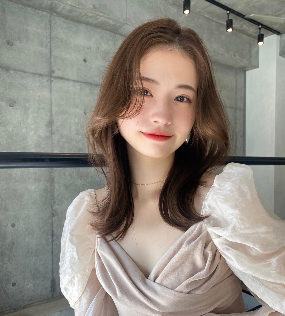 ผู้หญิงเอเชียไว้ผมยาวประบ่า ผมสีน้ำตาลเข้ม ทรงผมดัดปลาย