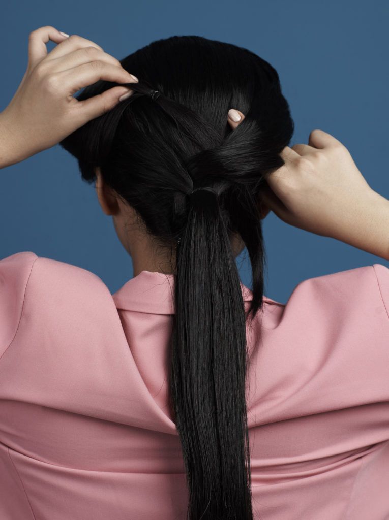 ผู้หญิงผมยาวสีดำ มัดผมหางม้า สวมสูทสีชมพู