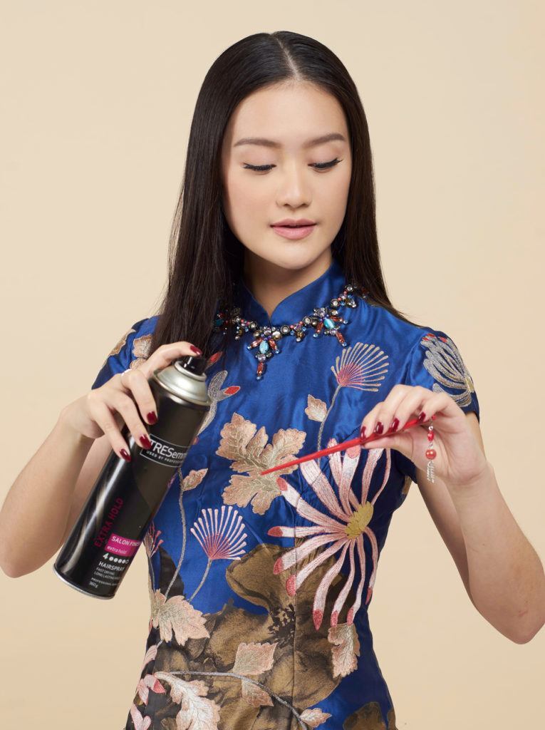 สาวเอเชีย ผมยาวตรง ฉีดสเปรย์บนหวี