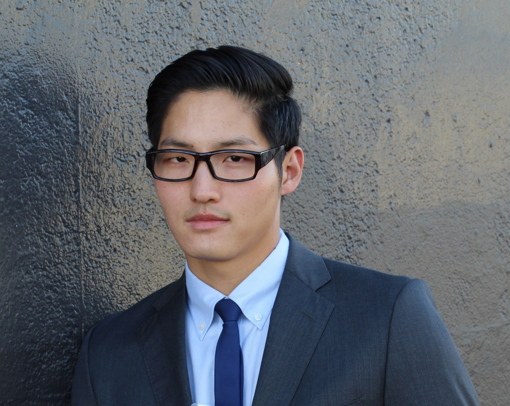 ผู้ชายใส่แว่น ใส่สูท เซ็ตผมแสกข้าง