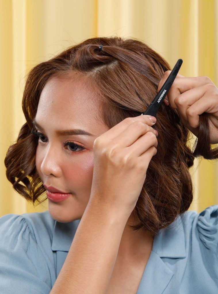 ผู้หญิงเอเชียผมสั้นสีน้ำตาล กำลังถักเปีย