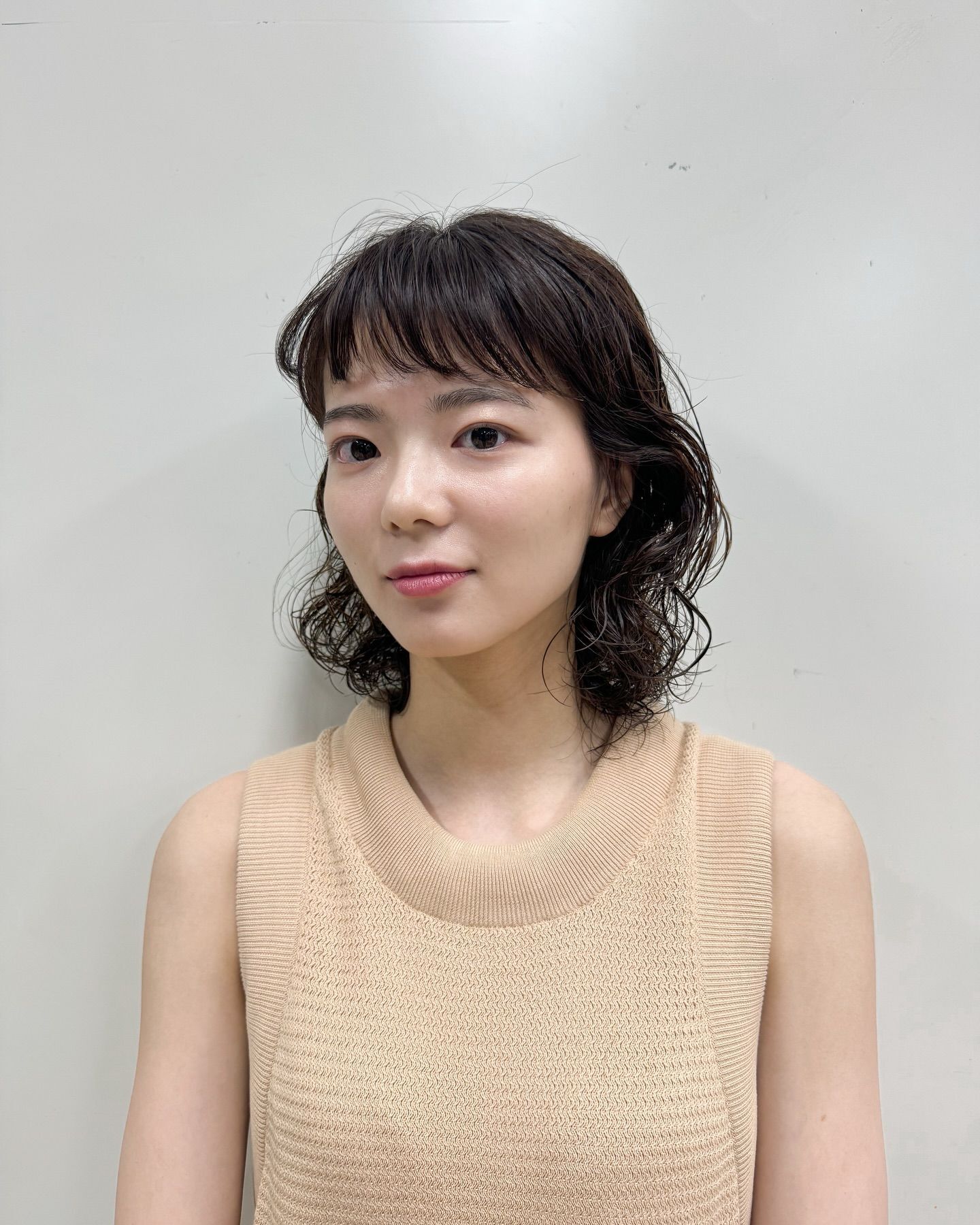 woman_short_dark_hair_wavy_perm_with_short_bang