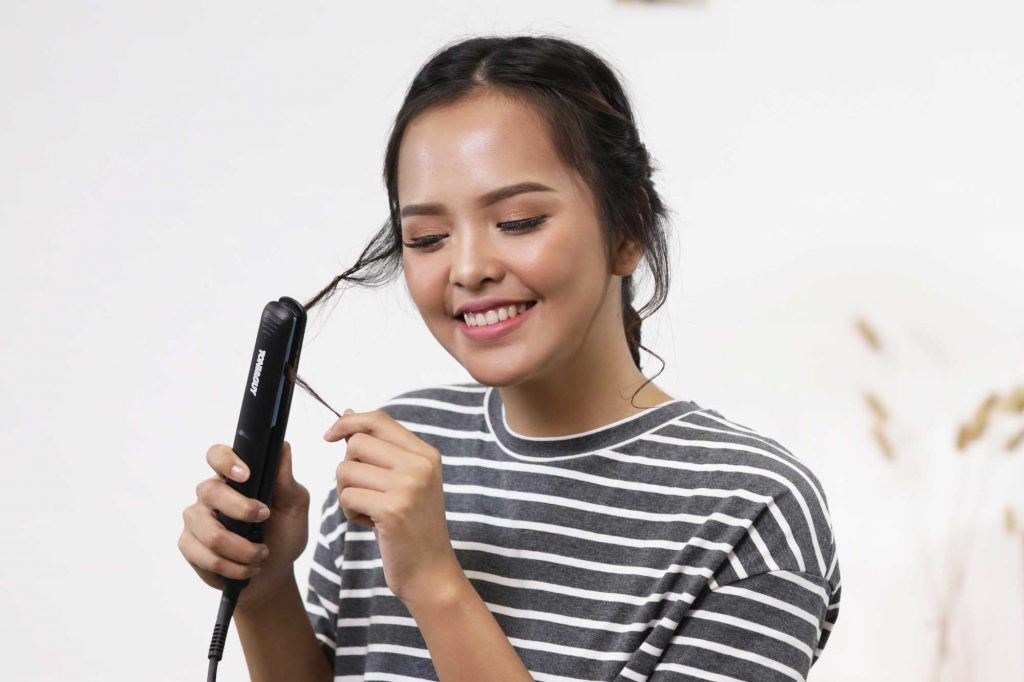 ผู้หญิงเอเชียผมยาวประบ่าสีดำ กำลังม้วนปอยผม