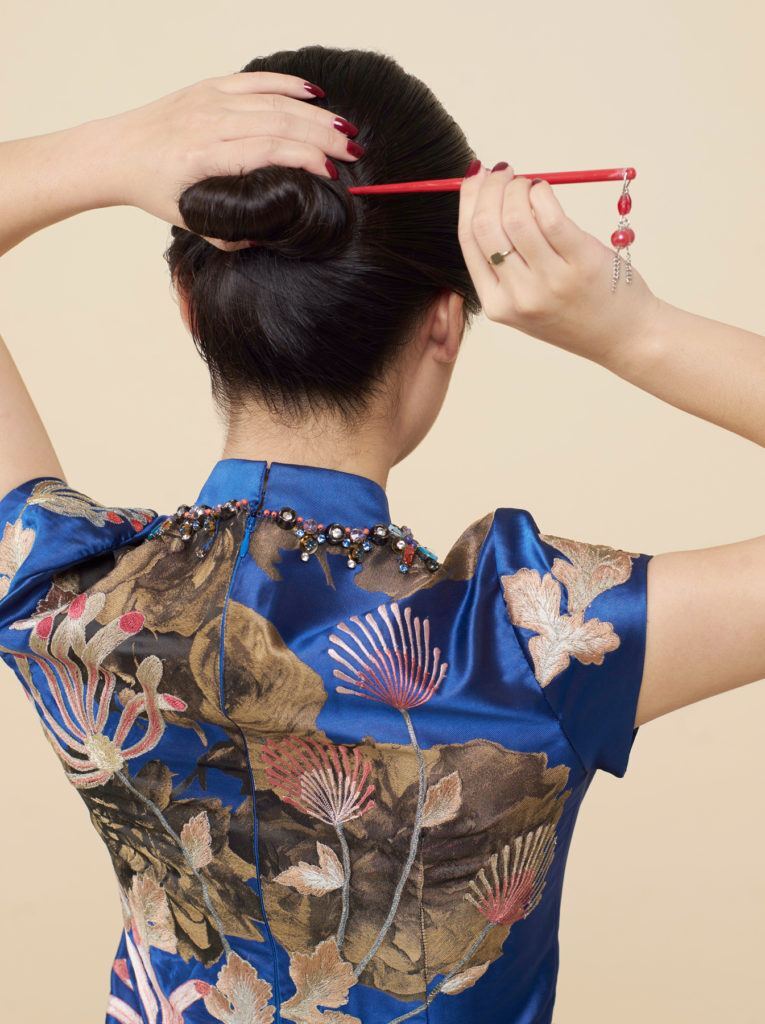 สาวเอเชีย หันหลัง ทำทรงผมเกล้า ใส่ปิ่นปักผม