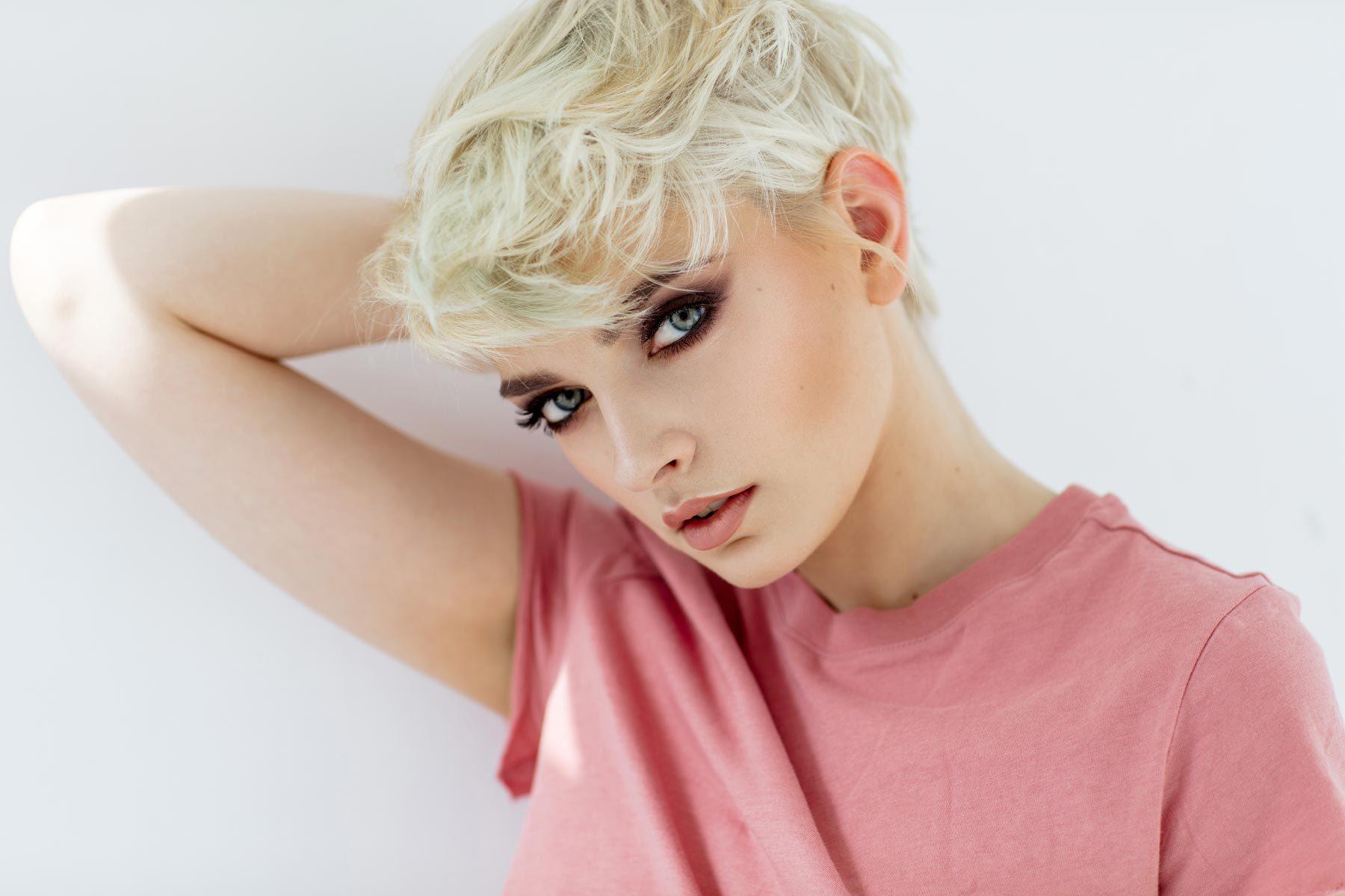 ผู้หญิงผมสั้น ย้อมผมสีบลอนด์ทอง ใส่เสื้อสีชมพู