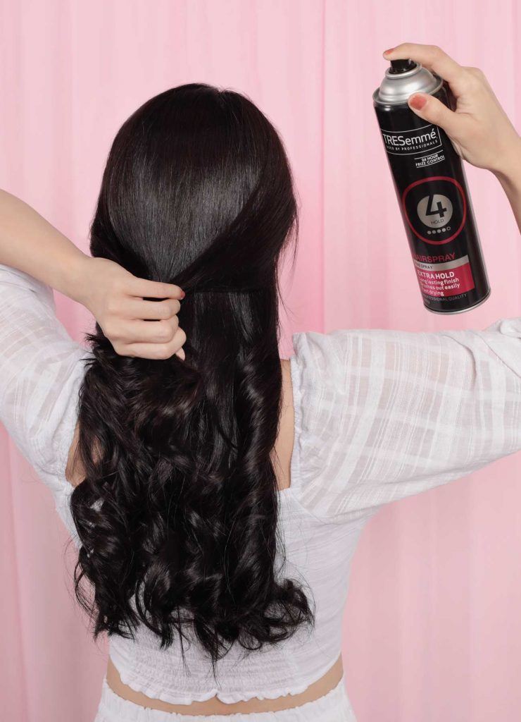 ผู้หญิงเอเชีย หันหลัง ผมยาวสีดำ กำลังฉีดสเปรย์แต่งผม