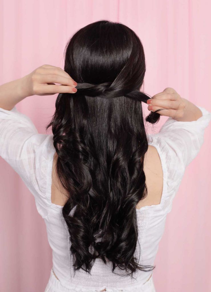 ผู้หญิงเอเชีย ผมยาวสีดำ กำลังมัดผมครึ่งหัว