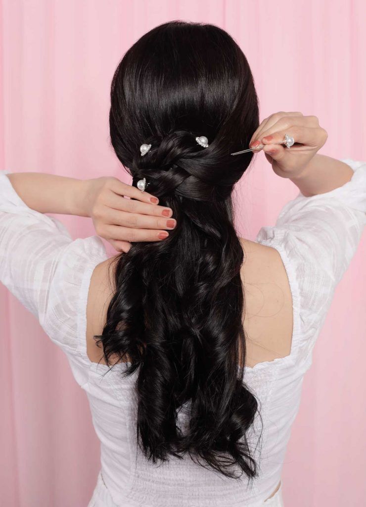 ผู้หญิงเอเชีย ผมยาวสีดำ กำลังเสียบกิ๊บมุกลงบนผม