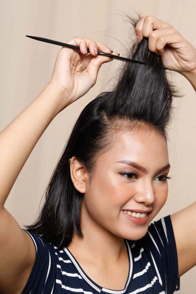 ผู้หญิงเอเชียหน้ากลมผิวคล้ำผมสั้น กำลังยีผม