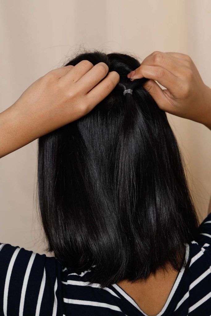 ผู้หญิงเอเชียหน้ากลมผิวคล้ำผมสั้น กำลังทวิสต์ผม