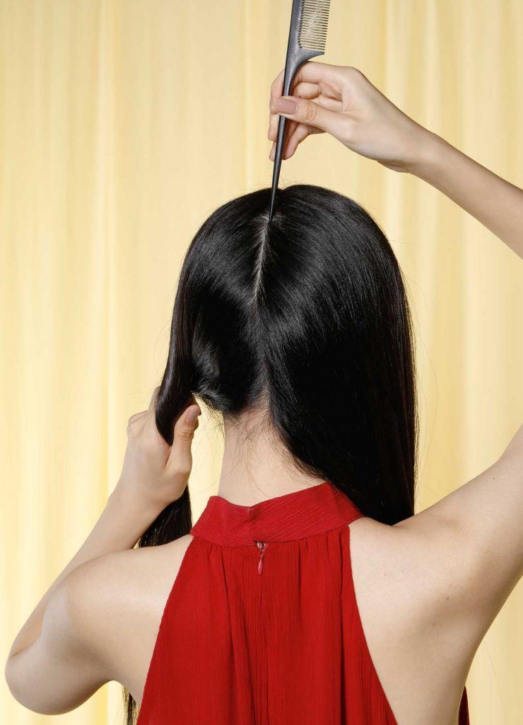 ผู้หญิงเอเชียผมยาวสีดำ กำลังใช้หวีหางแสกผม