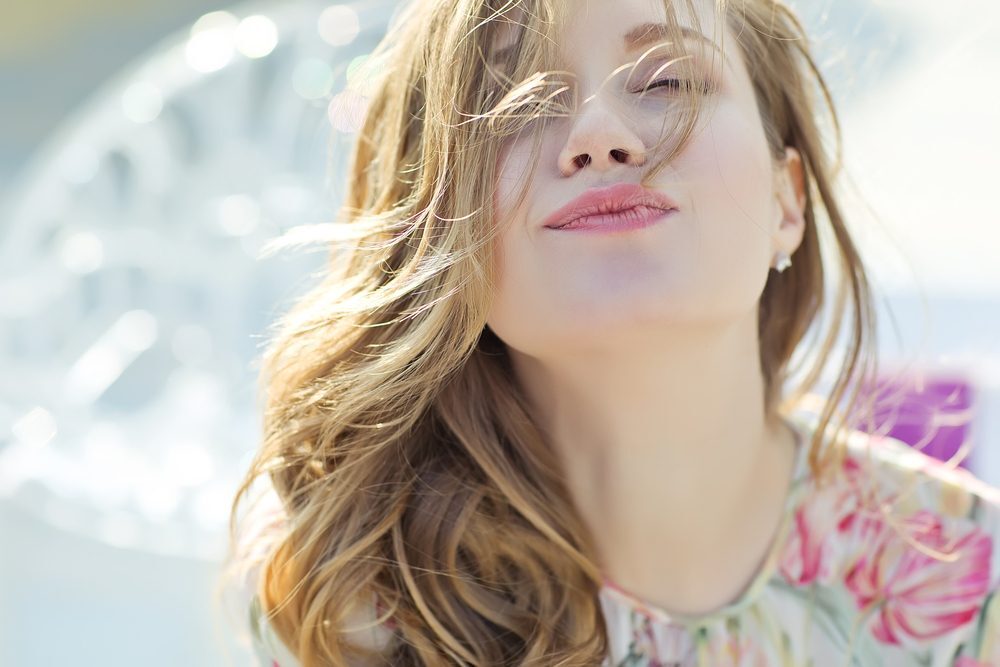 ผู้หญิงผมยาว ดัดลอน ย้อมสีน้ำตาลอ่อน ผมพลิ้วสวย ดูสุขภาพดี