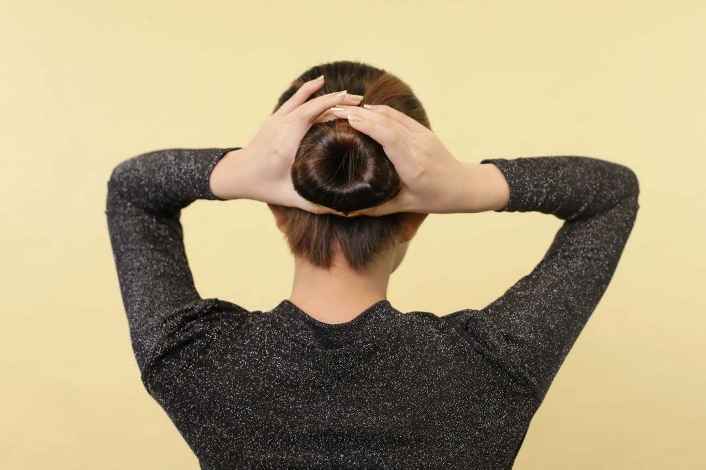 ผู้หญิงเอเชีย ผมสั้นสีดำ ครอบโดนัทบนผม และมัดผม