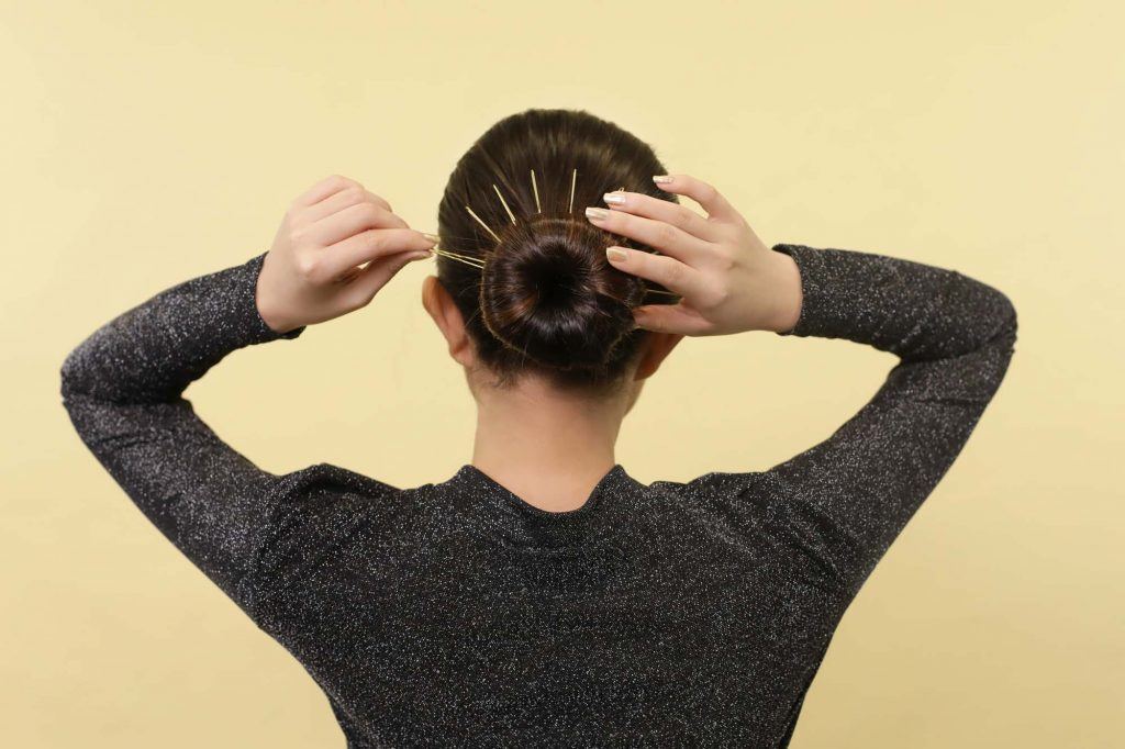 ผู้หญิงเอเชีย ผมสั้นสีดำ กำลังเสียบกิ๊บ ลงบนผม