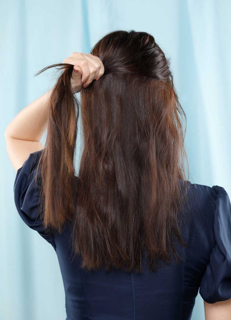 ผู้หญิงเอเชียผมยาวสีดำ กำลังมัดผมครึ่งหัว