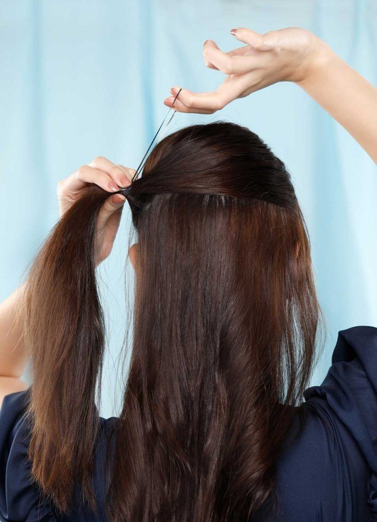 ผู้หญิงเอเชียผมยาวสีดำ กำลังมัดผมครึ่งหัว