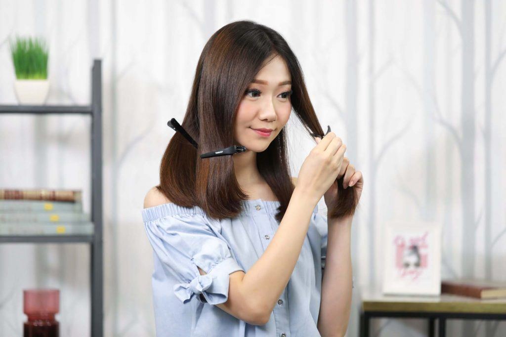 ผู้หญิงเอเชียผมยาวประบ่าสีดำ กำลังแบ่งผม