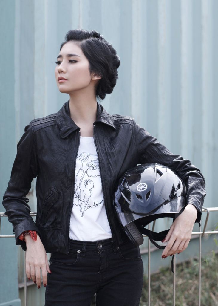 ผู้หญิงใส่เสื้อหนังสีดำ ถือหมวกกันน็อค