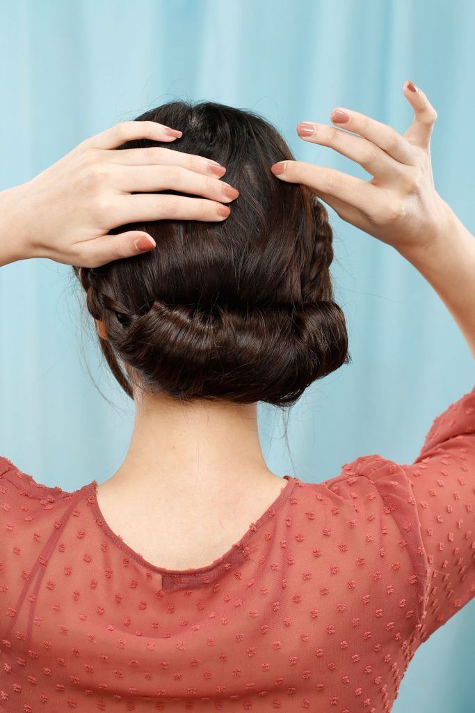 ผู้หญิงเอเชียผมยาวสีดำ กำลังเกล้าผมเปีย