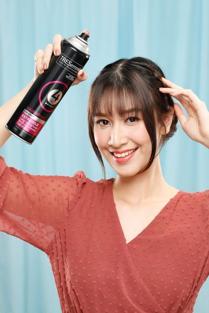 ผู้หญิงเอเชียผมยาวสีดำ กำลังฉีดสเปรย์แต่งผม