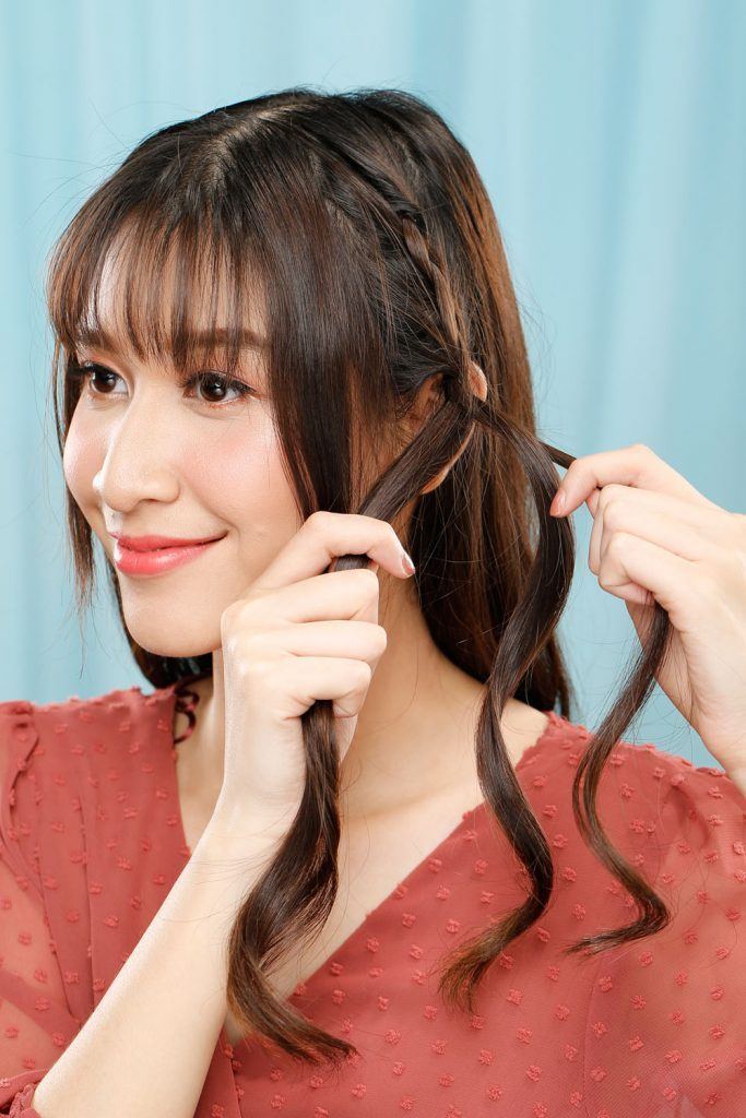 ผู้หญิงเอเชียผมยาวสีดำ กำลังถักเปีย