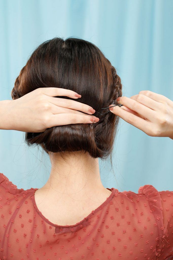 ผู้หญิงเอเชียผมยาวสีดำ กำลังเกล้าผมเปีย