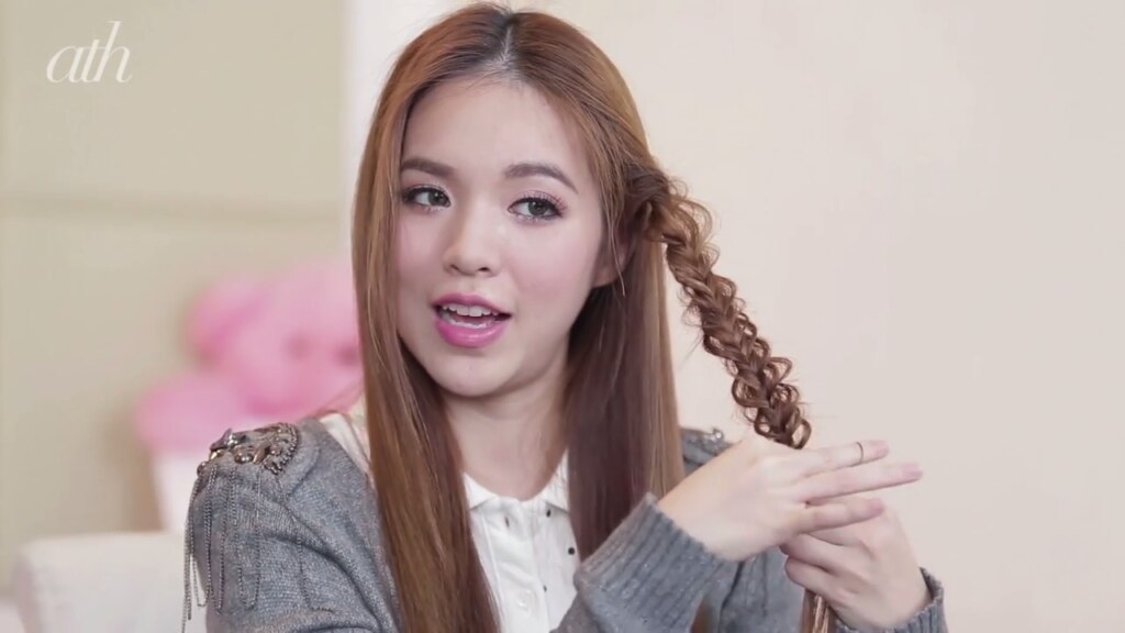 ผู้หญิงเอเชีย ไว้ผมยาว สีน้ำตาล กำลังถักเปีย