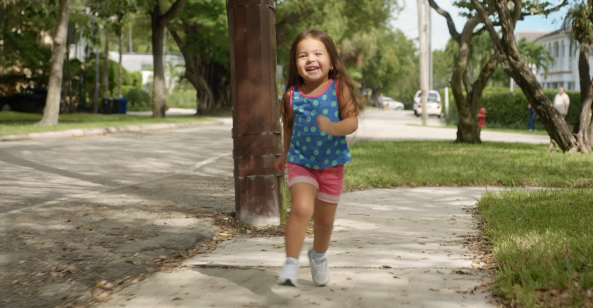 A girl running down the street smiling 