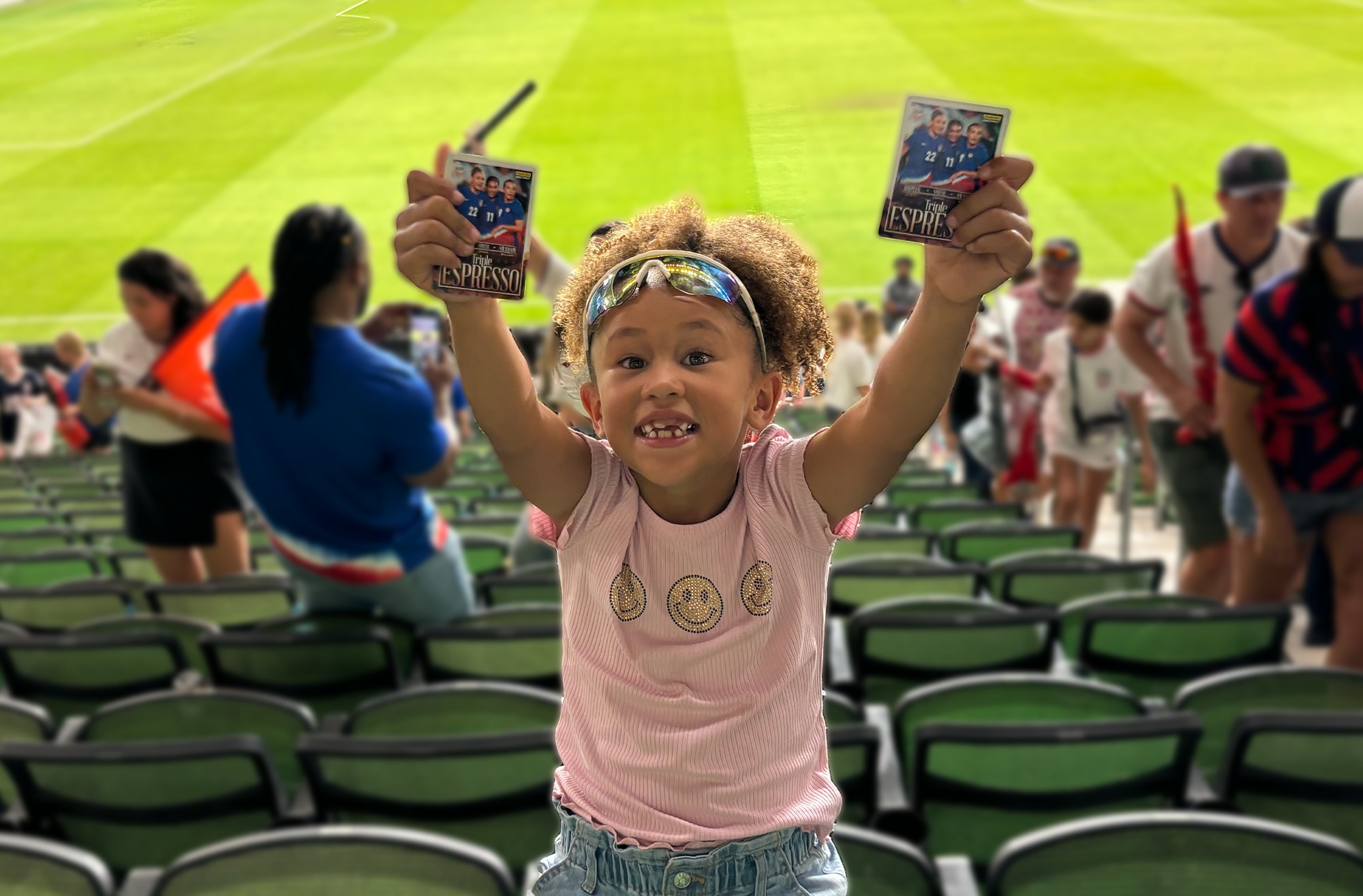Ziel smiling with her arms raised at a football stadium 