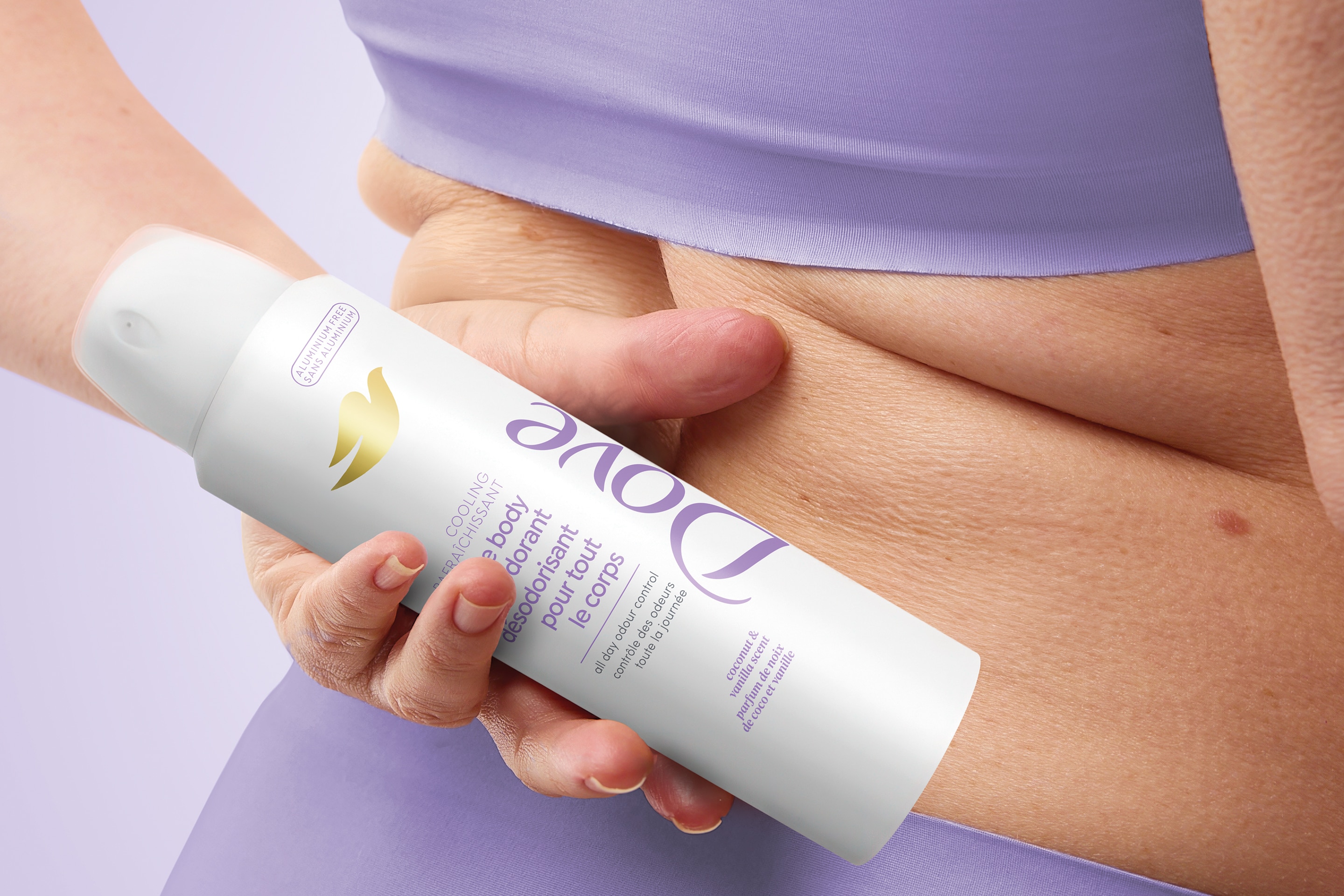 A woman wearing red top and gray trouser. She is laughing and touching her head.